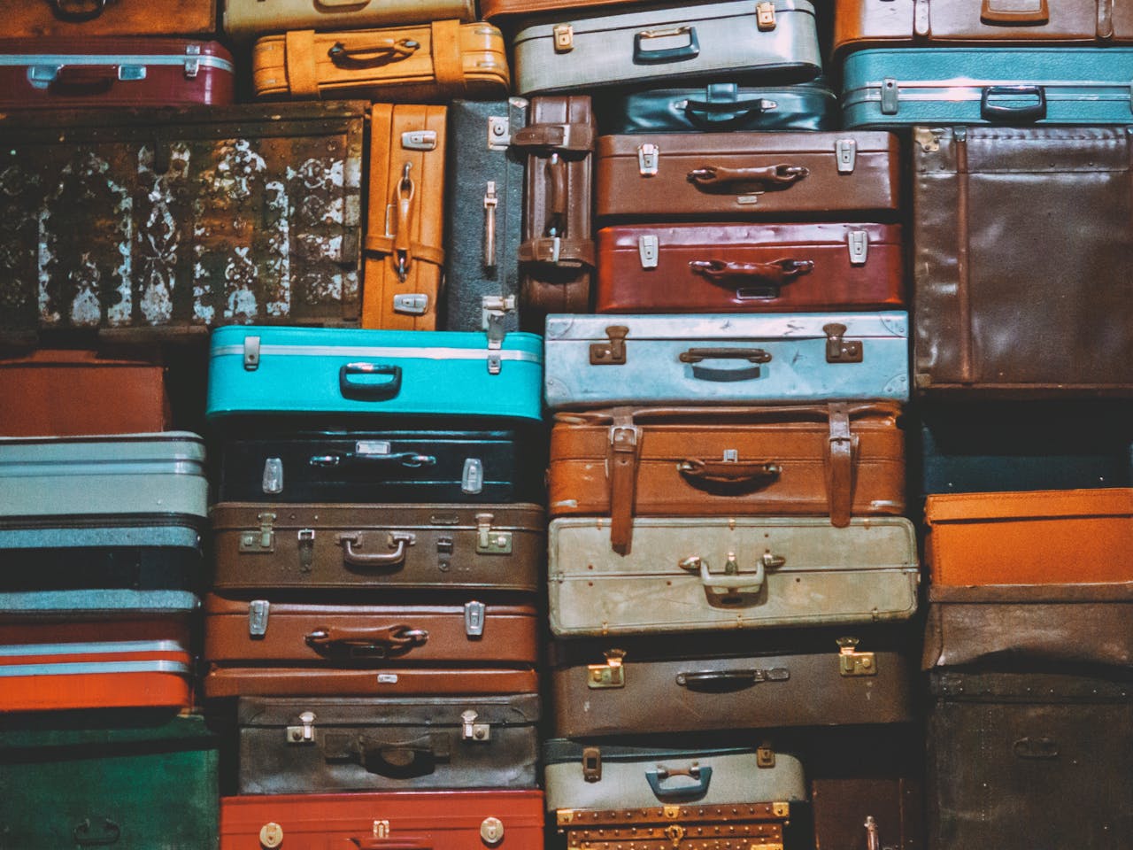 A colorful assortment of vintage suitcases stacked together, creating an artistic display.